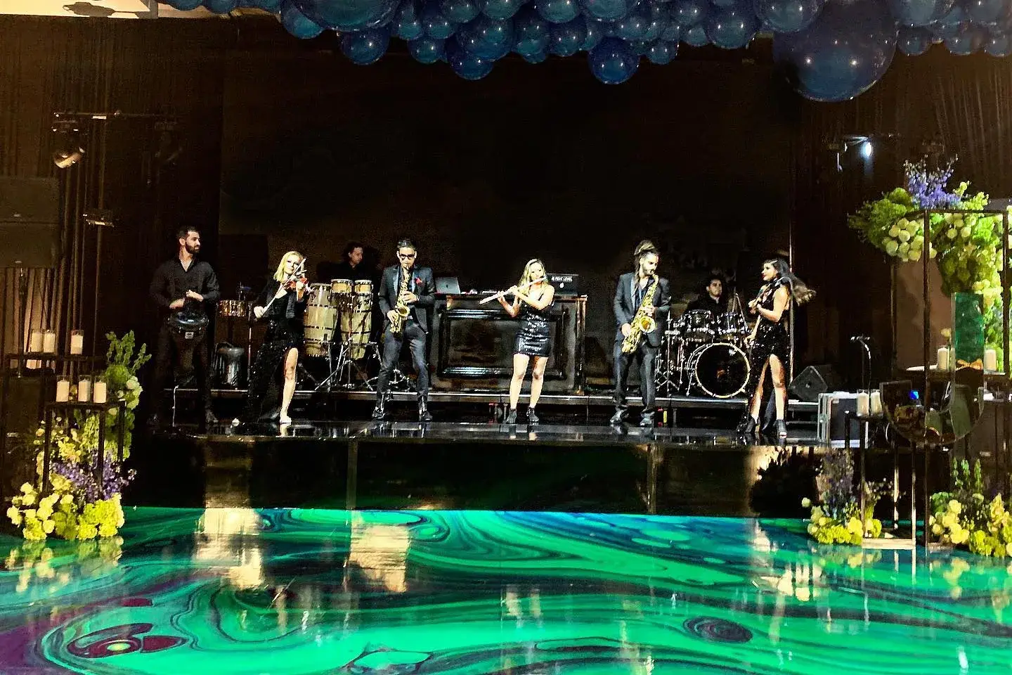 Live band performing on a stage with a full sound system at an evening event